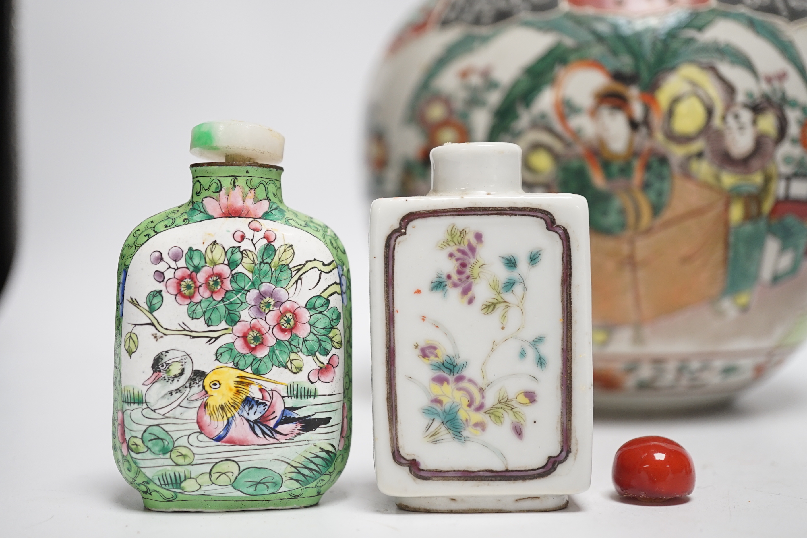 An early 20th century Japanese famille rose snuff bottle together with three others and a lidded jar